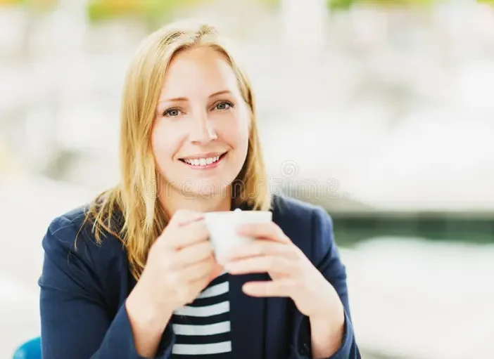 Immagine di una donna sorridente che beve un caffe